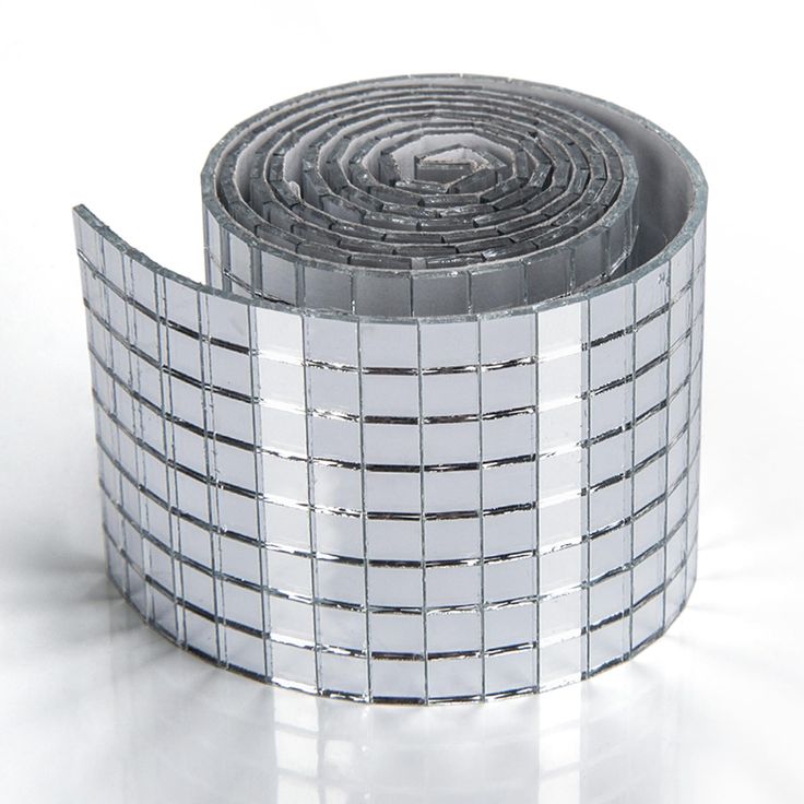 a roll of reflective tape sitting on top of a white surface with silver squares around it