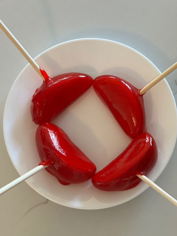 two hot dogs on skewers in a white bowl