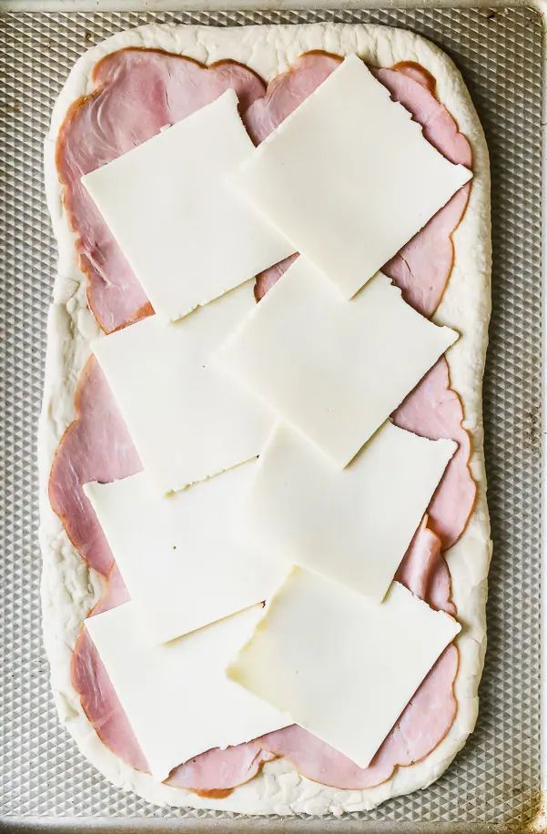 ham and cheese are cut into squares on a baking sheet