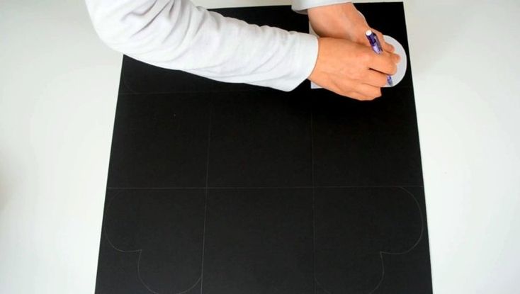 a person writing on a piece of black paper