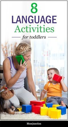 a woman sitting on the floor playing with her child and talking on a cell phone