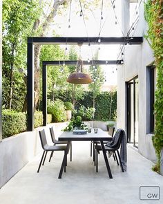 an outdoor dining area with white walls and black chairs is featured in the magazine's website