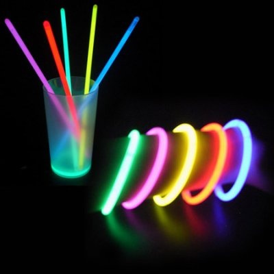 neon colored straws are in a glass on a black background