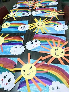 a table topped with lots of paper cut out of clouds and rainbows on it