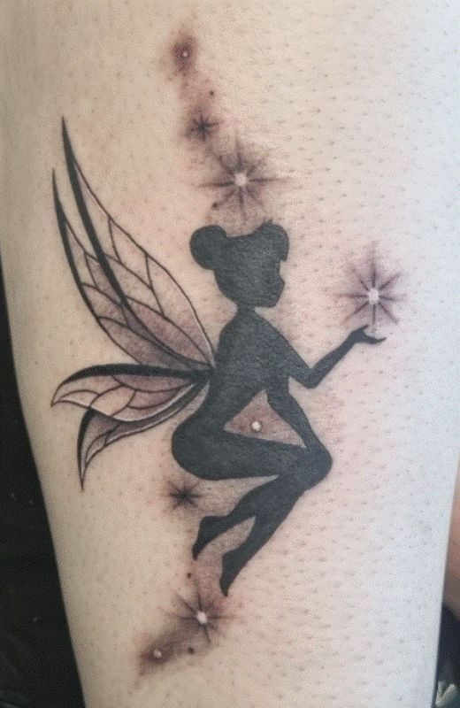 a woman's thigh with a fairy tattoo on her leg and stars in the background