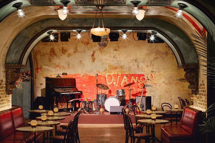 an empty restaurant with lots of tables and chairs in front of a large painting on the wall