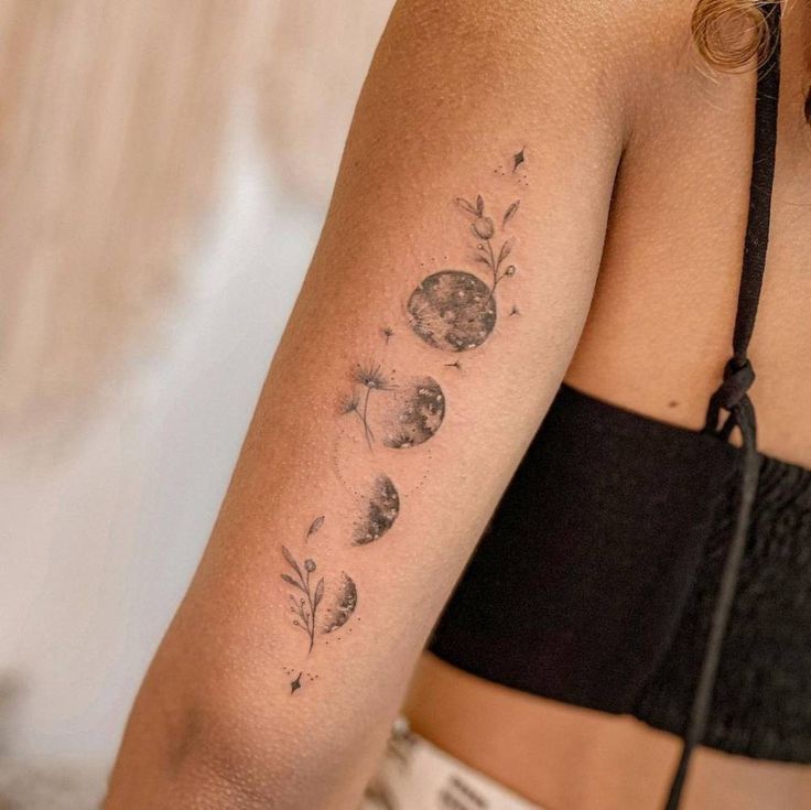 a woman's arm with flowers and leaves tattooed on the left side of her arm