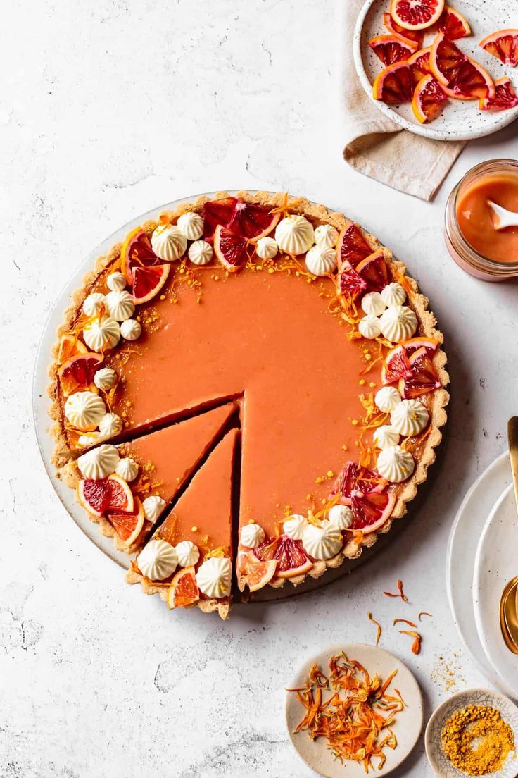 a pie is shown on a table with other desserts and condiments around it