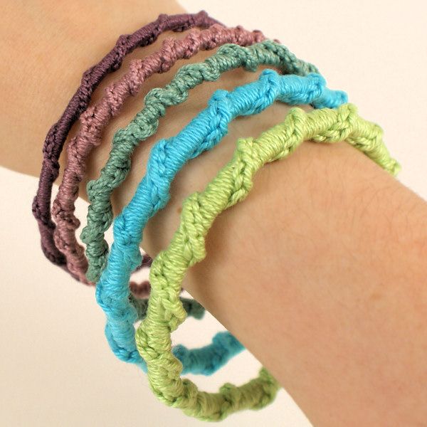 a woman's arm with four crocheted bracelets on it