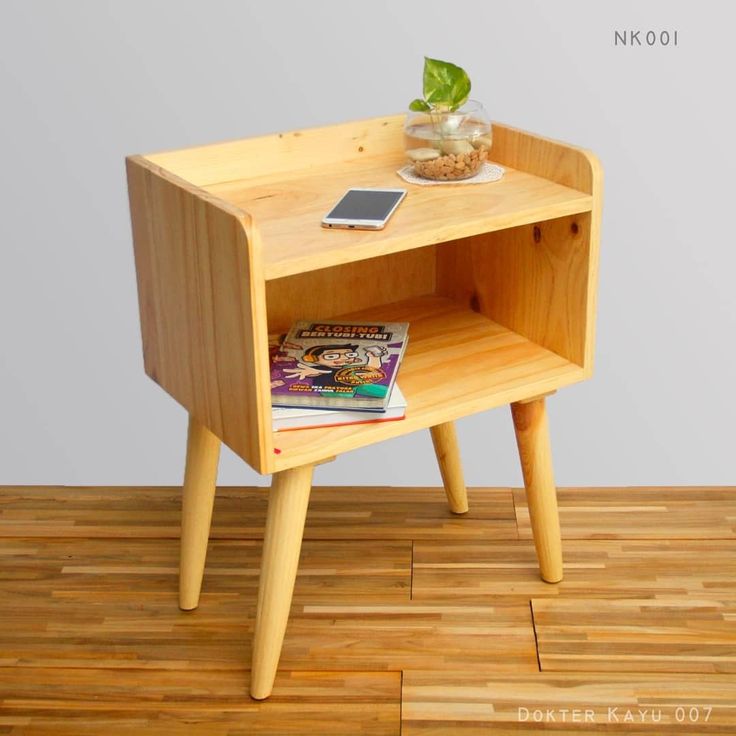 a small wooden table with a magazine on it and a cell phone sitting on top