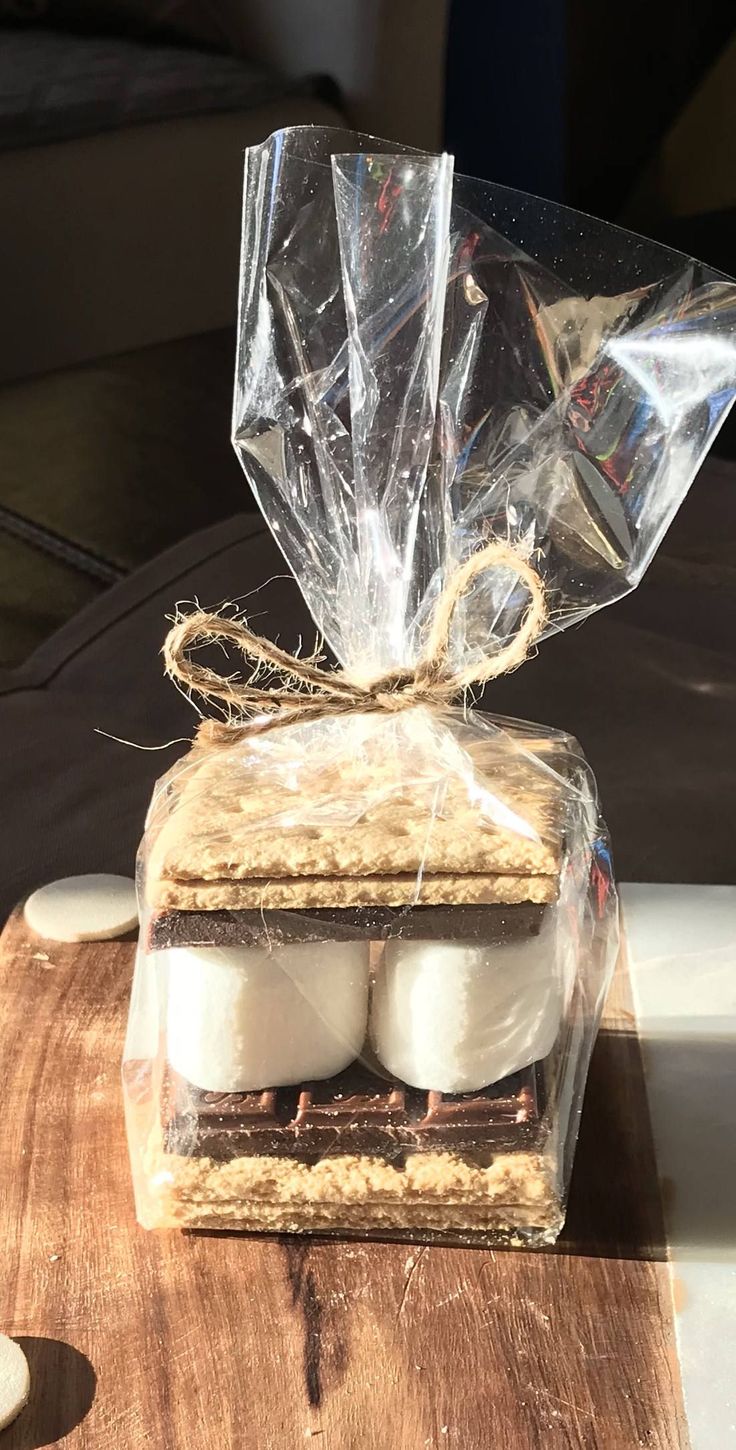 two marshmallows wrapped in plastic sitting on top of a wooden cutting board