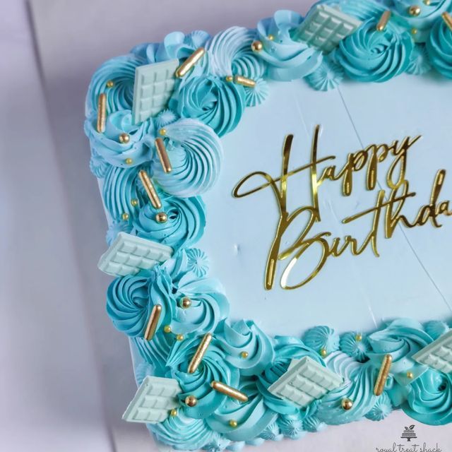 a happy birthday cake with blue icing and gold writing on it's side