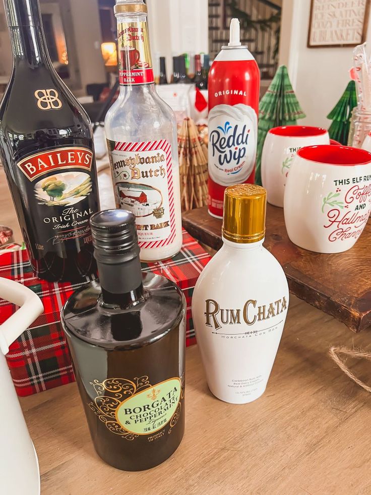 bottles of alcohol are sitting on a table next to other christmas decorations and holiday gifts