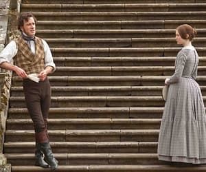 two people dressed in period clothing standing on steps