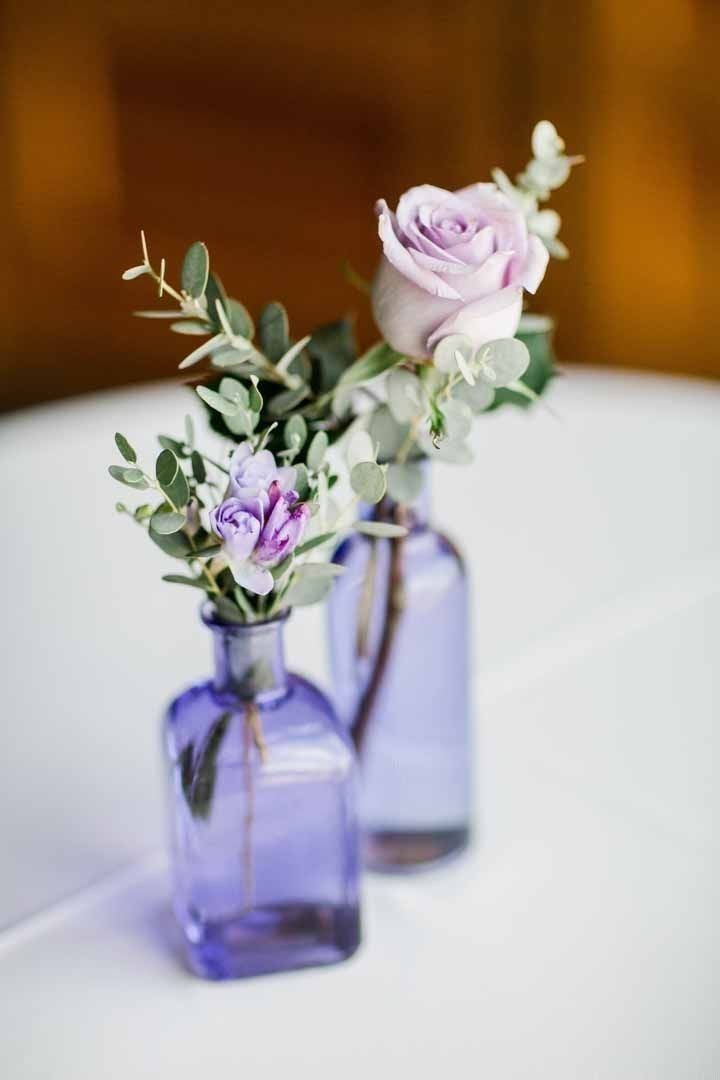 two vases with flowers are sitting on a table