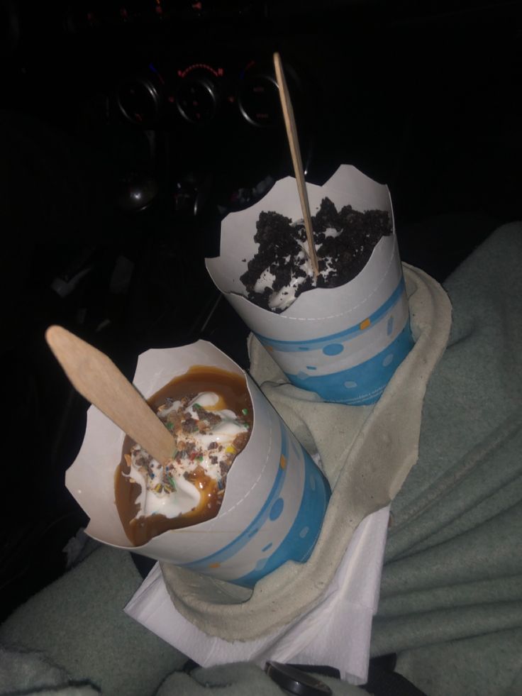 two cups filled with food sitting on top of a blanket