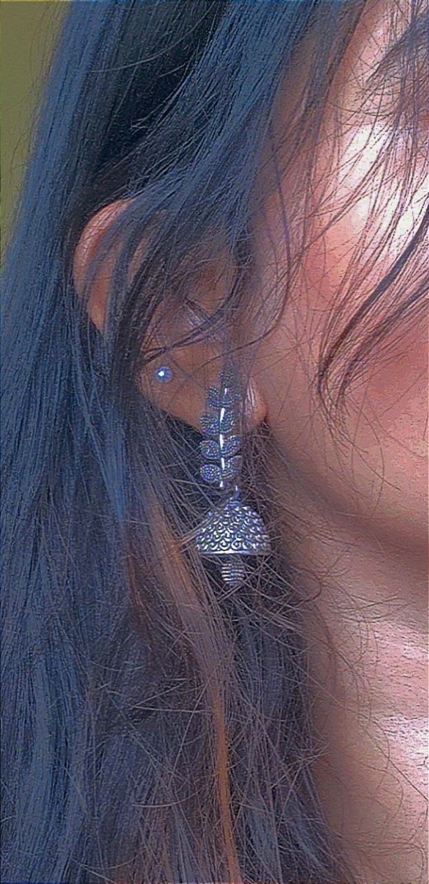 a close up of a person's face with ear piercings on their ears