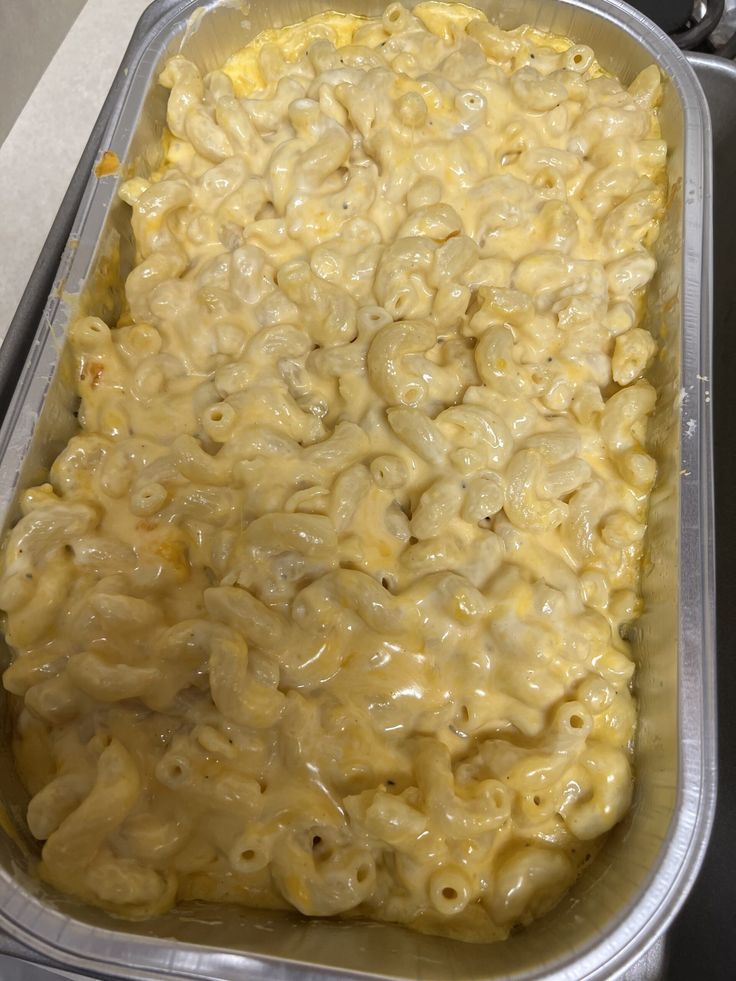 a pan filled with macaroni and cheese on top of a stove