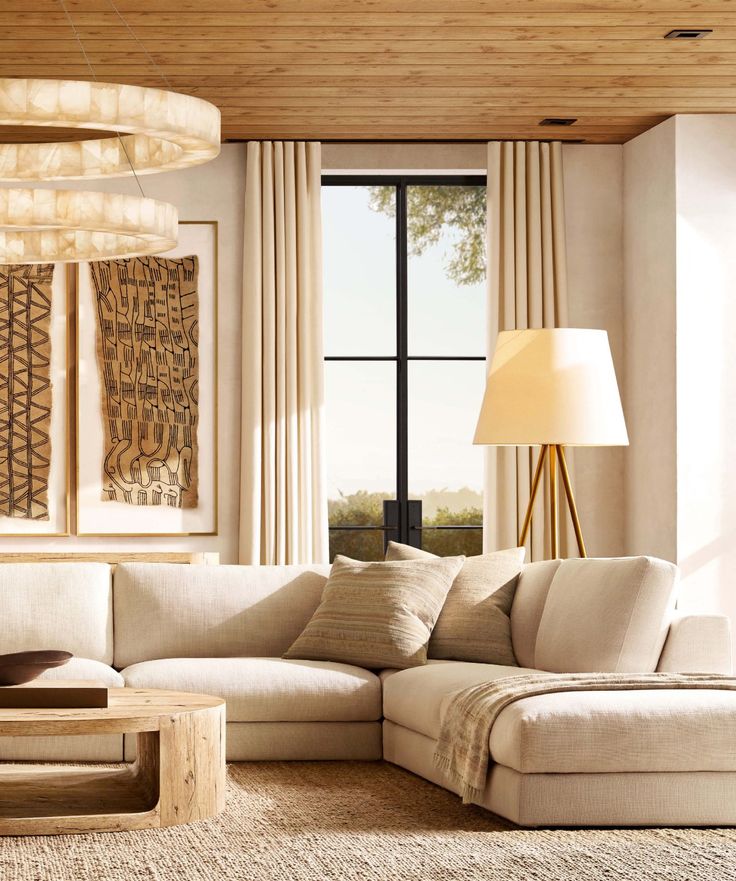 a living room filled with furniture next to a large window covered in beige drapes