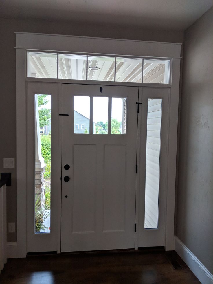 a white front door with two sidelights and glass panels on the top half of it