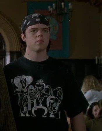 the young man is wearing a black shirt with skulls on it and has a bandana around his head