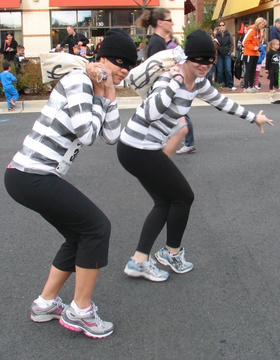 two women in striped shirts and black leggings playing with a frisbee