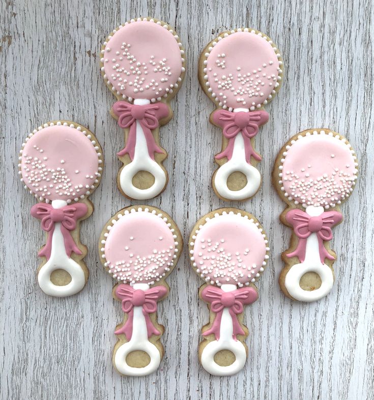 six decorated cookies with pink and white icing