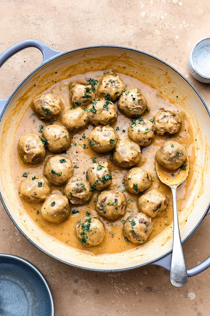 a pan filled with meatballs covered in gravy