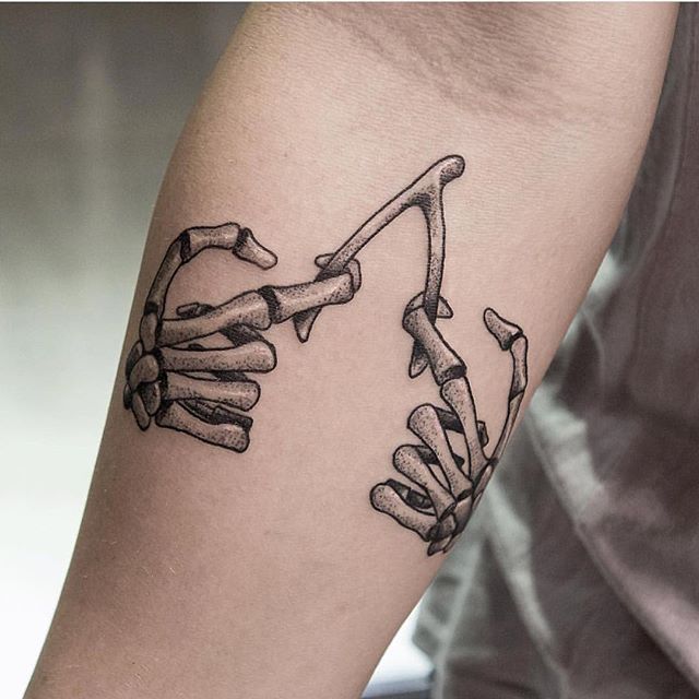 a tattoo on the arm of a man with two hands holding each other