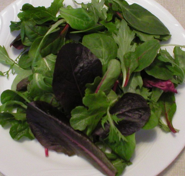 a white plate topped with lots of green leafy vegetables