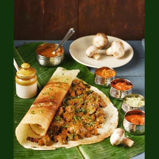 some food is laying out on a banana leaf with sauces and condiments