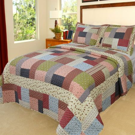 a bed in a bedroom with a colorful quilt on it