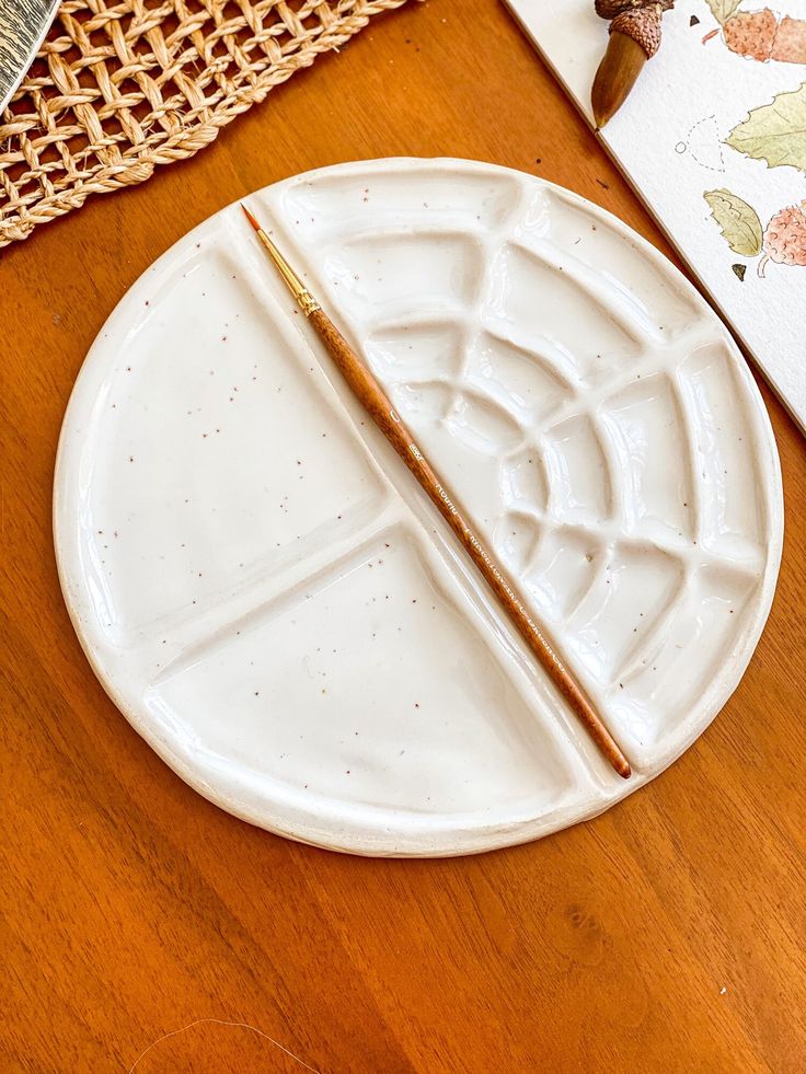 a wooden table with a white plate and two chopsticks on top of it