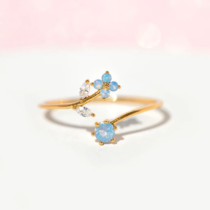 From it's beautiful vine-like features to subtle whimsical elements, our Wandering Blossom Adjustable Ring is the perfect delicate piece to add to your collection. This adjustable ring features our best-selling blossom design and is coupled with a pair of cubic zirconia leaves and an opalescent stone at the base. 18k g Delicate Cubic Zirconia Flower Ring, Delicate Cubic Zirconia Crystal Ring, Cute Promise Rings, Pretty Jewelry Necklaces, Gold Color Ring, Blossom Design, Ring Fashion, Jewelry Lookbook, Fancy Jewelry