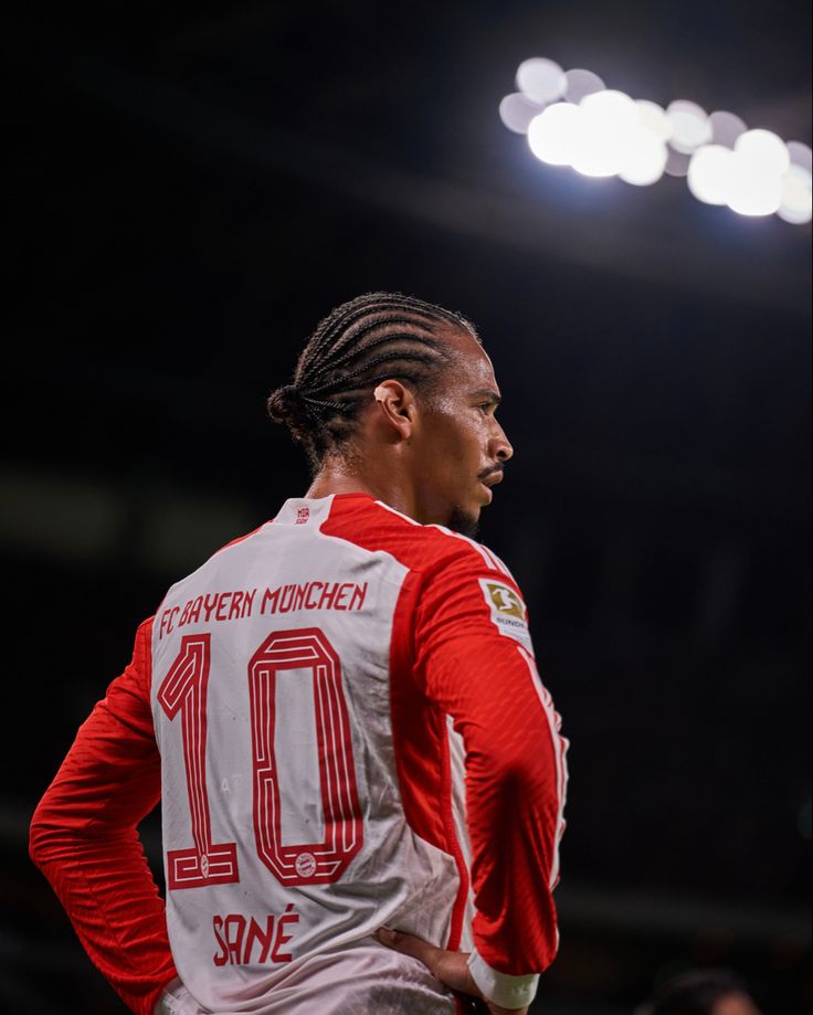 a man with dreadlocks standing on a basketball court