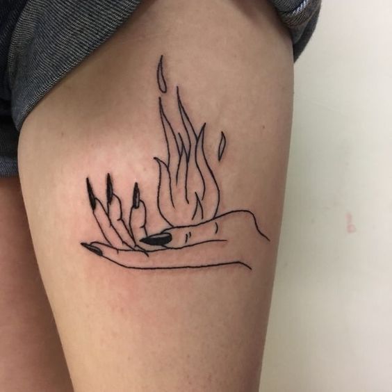 a woman's leg with a tattoo on it that has flames coming out of her hand