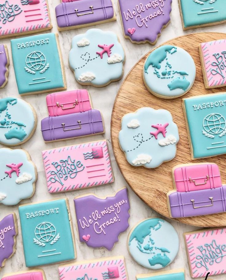 decorated cookies are arranged on a table with words and symbols in the shape of suitcases