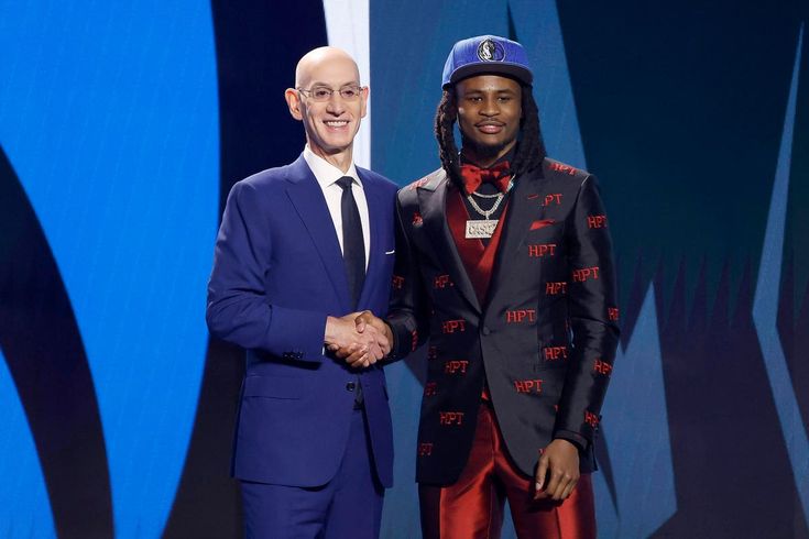 two men in suits shaking hands on stage