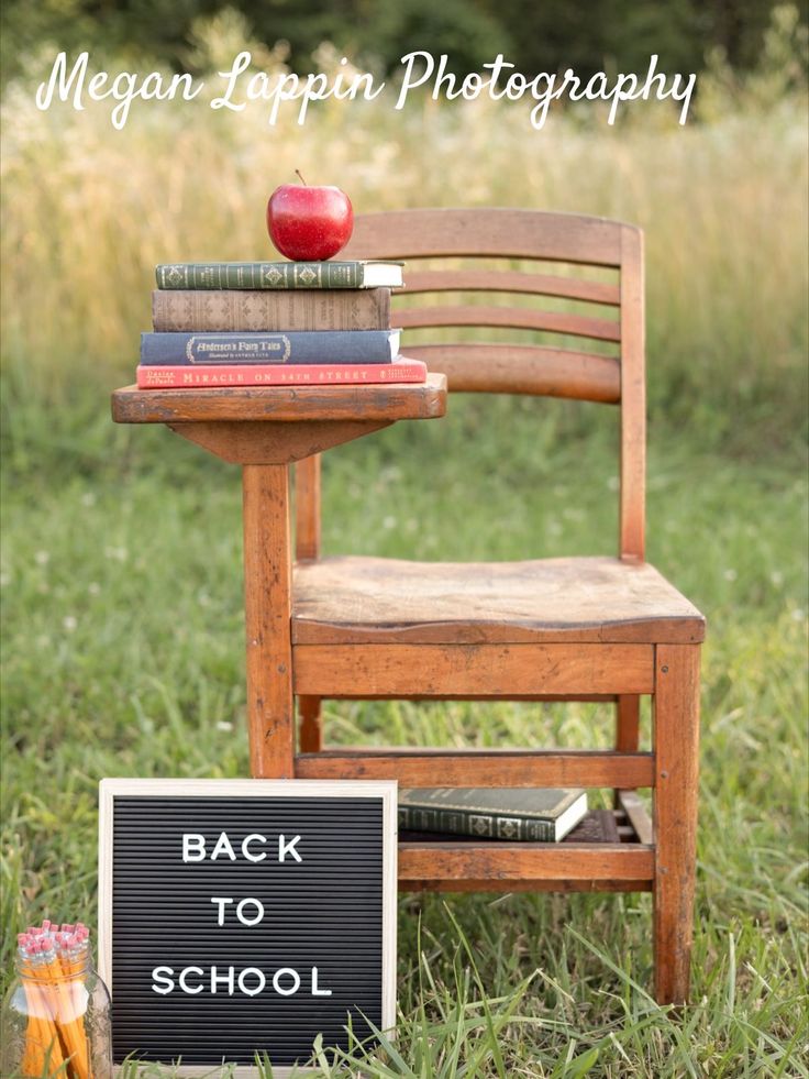 an apple sitting on top of a wooden chair next to books