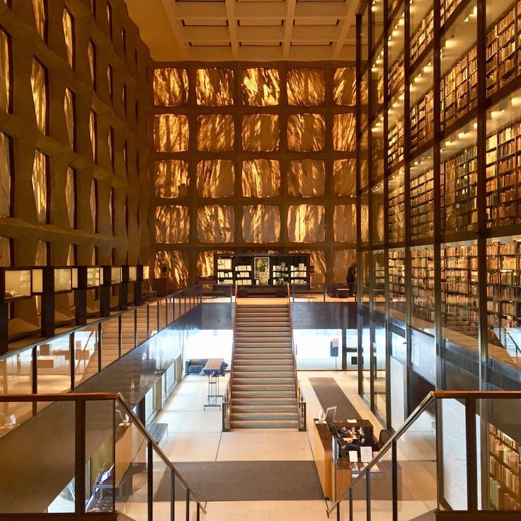 the inside of a library with many bookshelves and stairs leading up to it