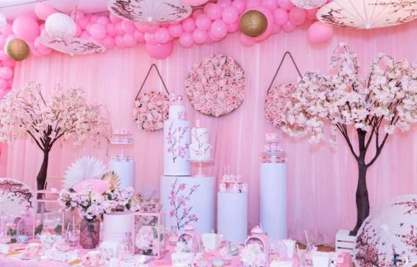 a table with pink decorations and balloons on it