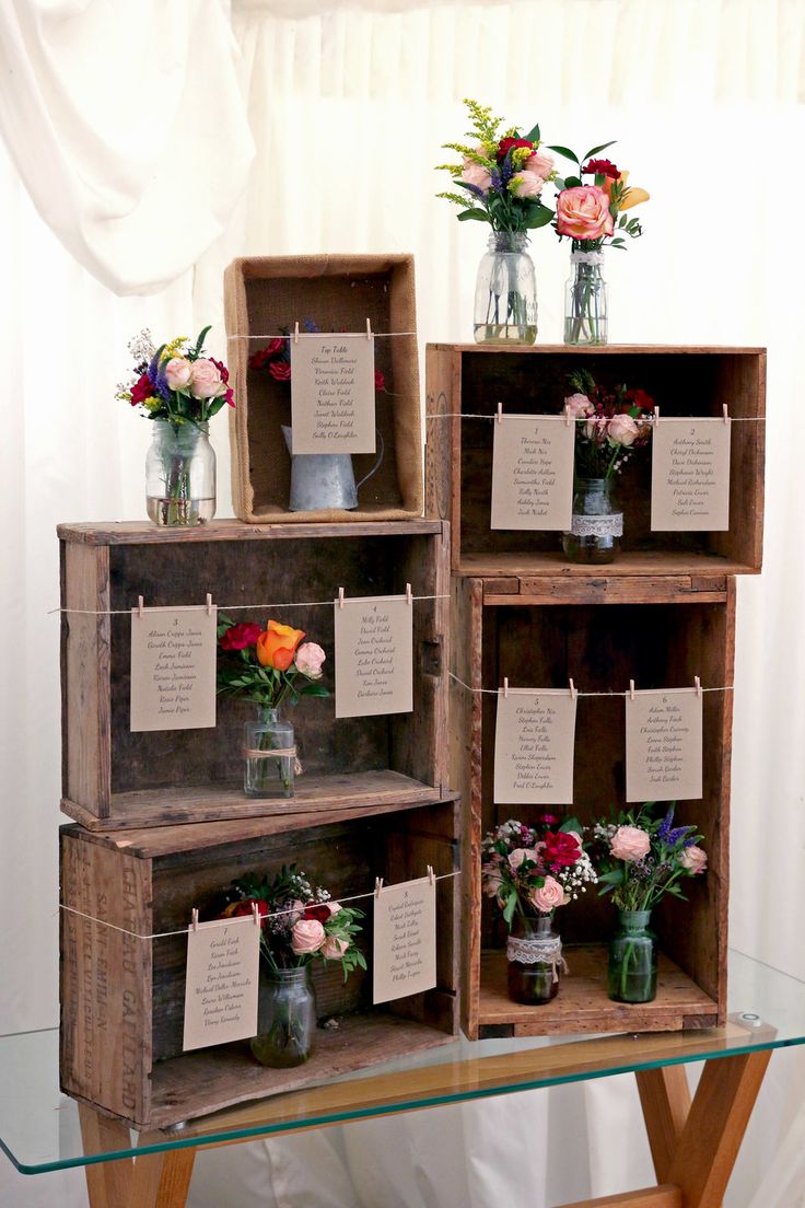 three wooden crates with flowers and notes on them