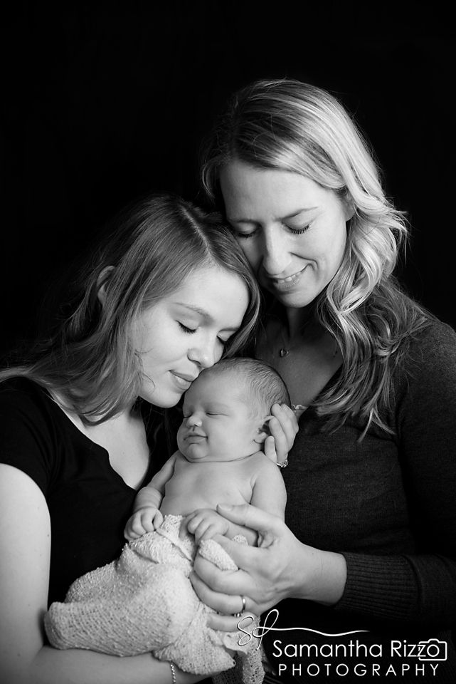 two women holding a baby in their arms