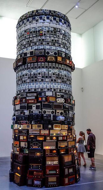 there is a very large stack of old radio's on display in the room