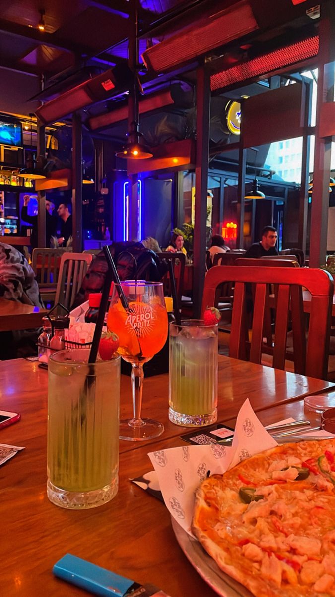 pizza and drinks on a table in a restaurant