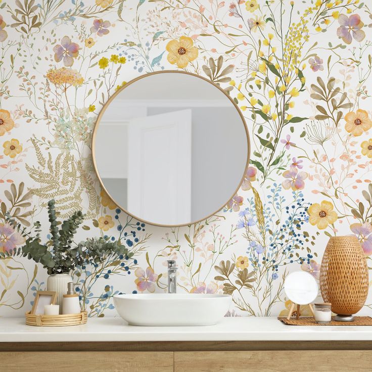 a bathroom with floral wallpaper and a round mirror on the wall next to a sink