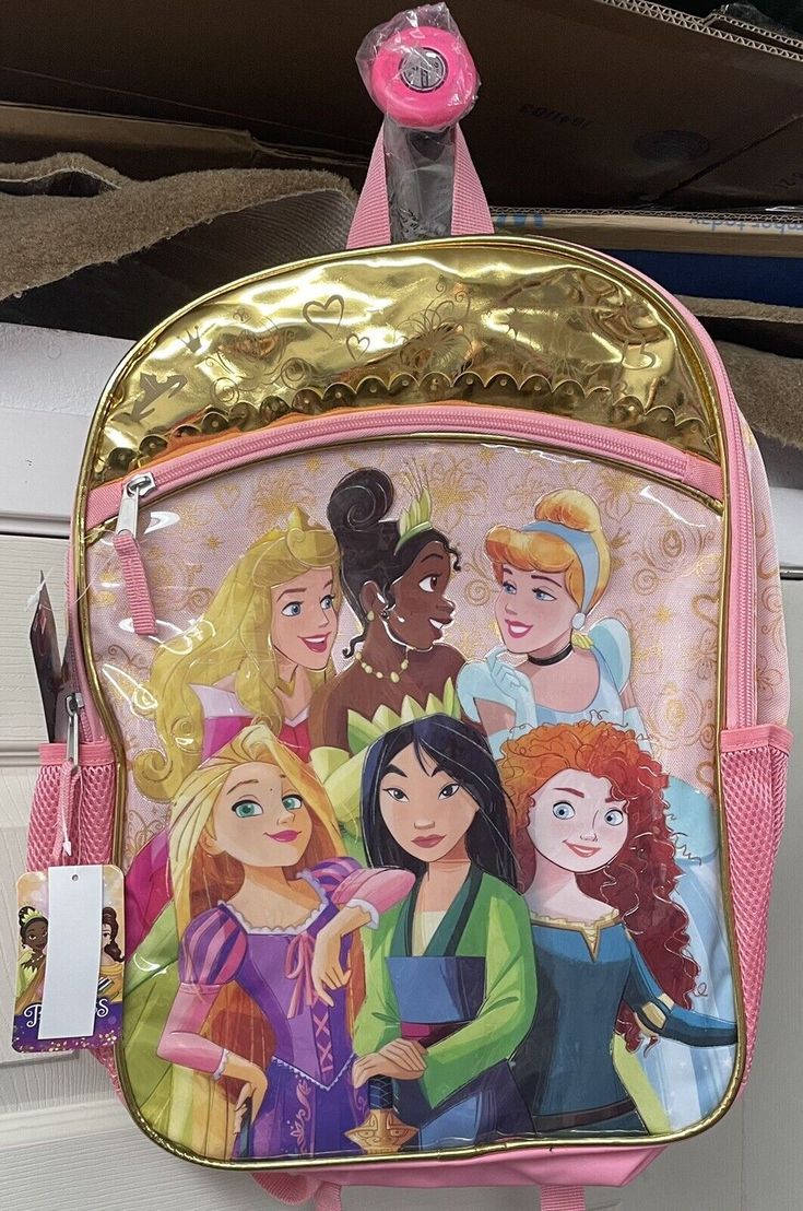 a pink and gold backpack with disney princesses on it's side hanging from the ceiling