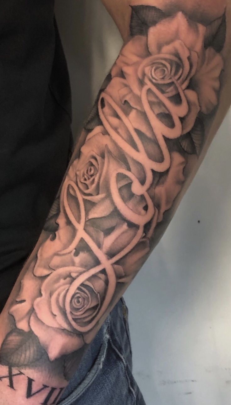 a man's arm with roses on it and the word love written in cursive