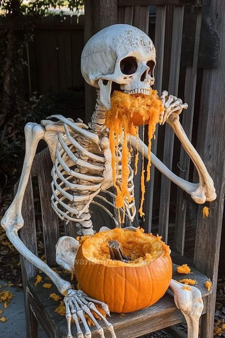 a skeleton sitting on a bench with food in it's mouth and eating from a pumpkin