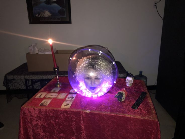 a table topped with a glass bowl filled with liquid and a lit candle on top of it